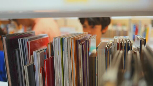Young boy choosing a children's storybook from a colorful bookshelf in a public library, representing childhood education, intellectual development, and learning through reading