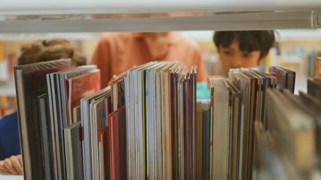 Curious kids exploring bookshelves in a public library, searching for children's literature, surrounded by colorful books and engaged in educational activities