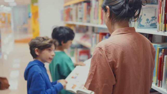 Teacher with students choosing a book in a library, children's literature, young readers learning, educational activity, childhood development, love of reading and knowledge