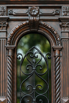 Carved wooden door with arched wrought iron window, classical ornaments detail, restored Odesa Ukraine