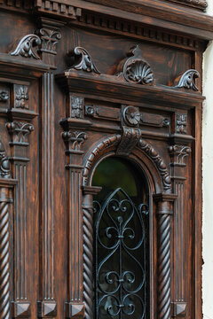 Carved wooden door with arched wrought iron window, classical ornaments detail, restored Odesa Ukraine