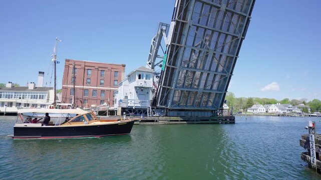 Mystic River Bascule Bridge, a historic drawbridge raised open over the water as a commercial boat passes the scenic downtown waterfront in Mystic, Connecticut.
