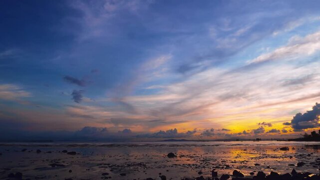 Colorful Sunset Over Rocky Tidal Flat and Dramatic Cloudy Sky