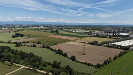 Italian Countryside Landscape: An expansive aerial view showcases the patchwork of cultivated fields and verdant pastures typical of the Italian countryside. © Andrew
