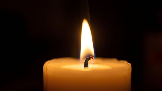Warm Candle Flame Flickering in Darkness with Gentle Smoke Swirls