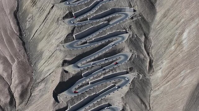 Cars on Winding Mountain Switchback Road in Barren Desert Landscape
