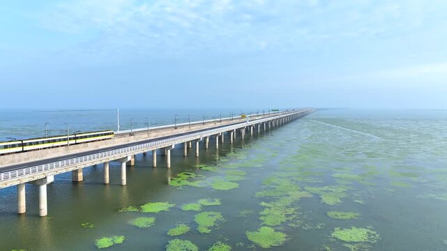Passenger Train Crossing Long Sea Bridge Over Blue Water