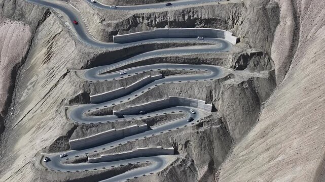 Cars on Winding Mountain Road in Barren Desert Landscape