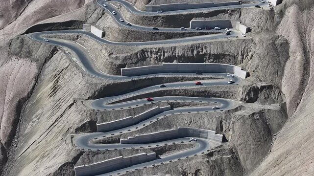 Cars on Winding Mountain Road Through Desert Terrain