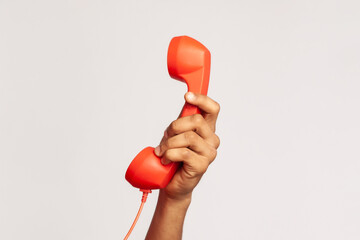 Profile portrait of male wearing red casual style T-shirt, screaming and yelling talking retro landline phone, complaining on connection quality. Indoor studio shot isolated on gray background. © khosrork