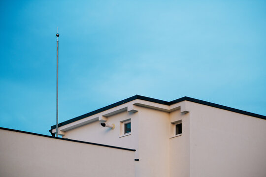 Modern apartment exterior with lightning rod and small windows, minimalist urban architecture composition