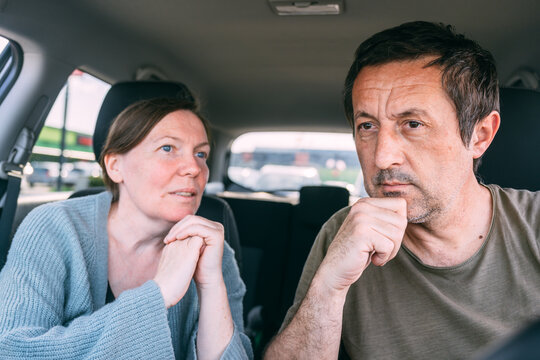Middle-aged couple having a serious conversation while sitting in a parked car