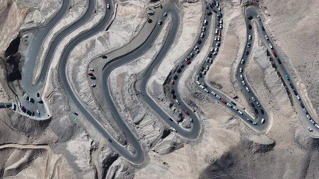 Cars on winding mountain road in desert landscape