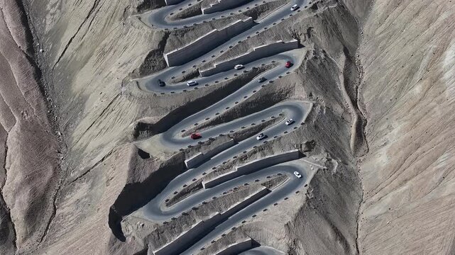 Cars on Winding Mountain Road in Desert Landscape