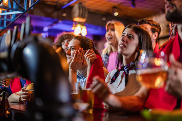 Disappointed sports fans looking sad and holding beer as their soccer team loses in a pub. © Mediteraneo