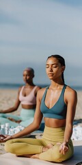 Obraz premium Female duo meditating cross legged near ocean shoreline