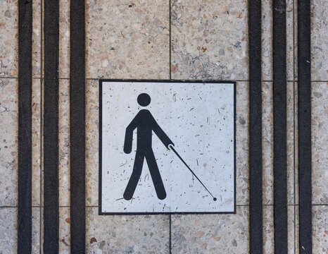 Tactile paving indicator with blind person symbol on a waiting room floor