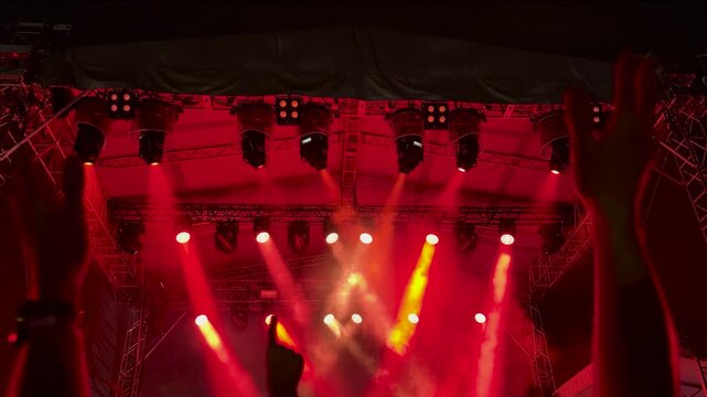Hands clapping in front of live concert stage lights