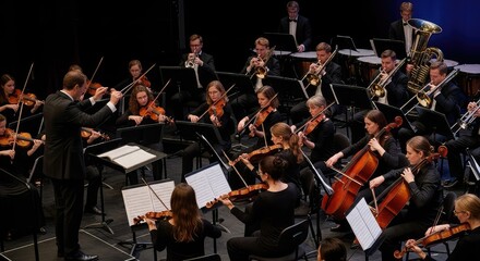 Fototapeta premium High angle view of a vibrant orchestral ensemble in unison, featuring a rhythmic baton, violins, brass, and sheet music under stage lights, creativity, percussion, sound