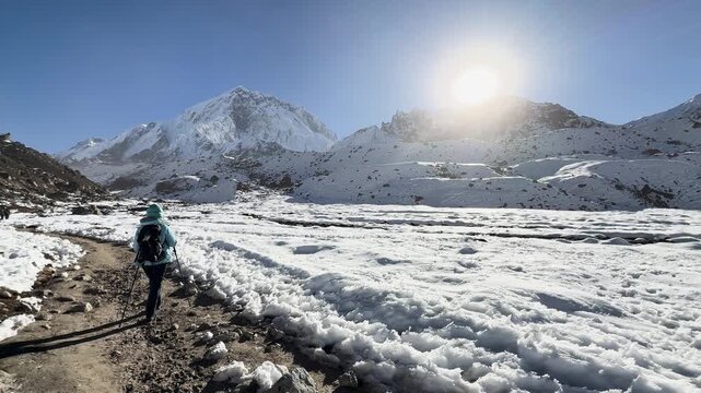 Hiker trekking toward snowy Himalayan peaks in Nepal