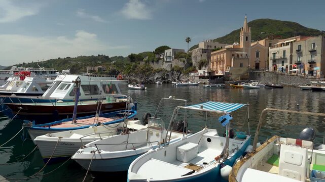 Lipari harbor with medieval citadel on volcanic rock, colorful waterfront buildings and moored boats, Aeolian Islands, Sicily, Italy