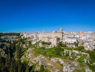 Naklejka premium Gravina in Puglia. Aerial drone panorama view of historic Italian townscape with Gravina di Matera river canyon landscape and Apulian architecture