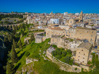 Obraz premium Gravina in Puglia. Aerial drone panorama view of historic Italian townscape with Gravina di Matera river canyon landscape and Apulian architecture