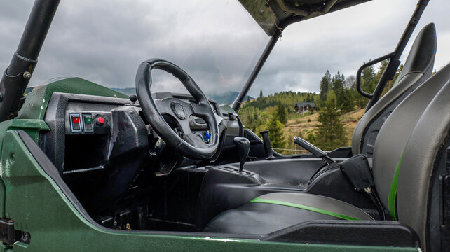 Interior view of a rugged all-terrain vehicle parked on a scenic mountain hillside