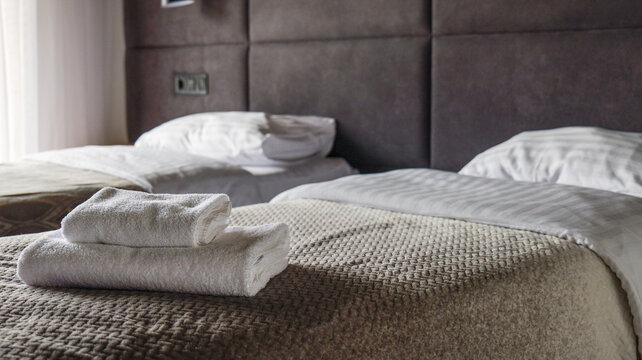 Comfortable hotel room with neatly folded towels on a made bed
