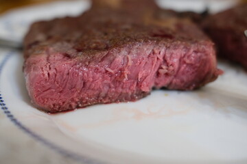 Fototapeta premium Medium rare ribeye steak, juicy cut close-up. Sliced medium rare rib eye steak showing juicy interior texture