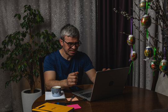 Angry freelancer reacting to problem while working on laptop at home