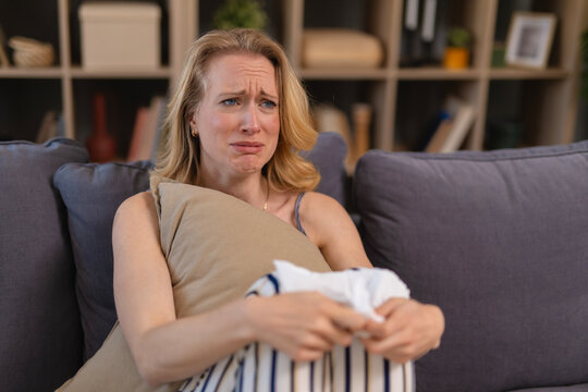 Woman crying on couch feeling sad and depressed