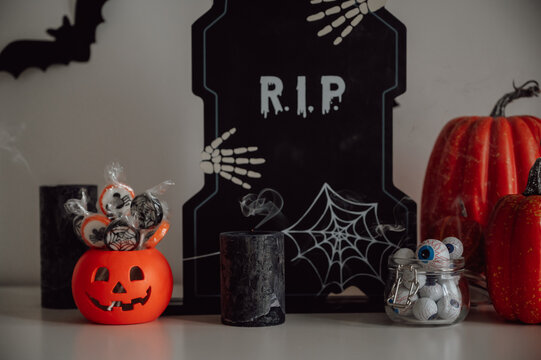 Halloween banner with festive decorations. Black candles, treats and rip sign on the table. Spooky and moody mood
