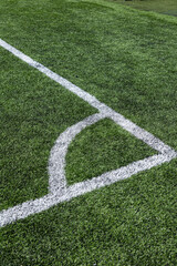 Fototapeta premium Close-up of an artificial turf sports field with marked lines crossing on synthetic grass. Outdoor sports surface suitable for football, soccer, training, and recreational activities.