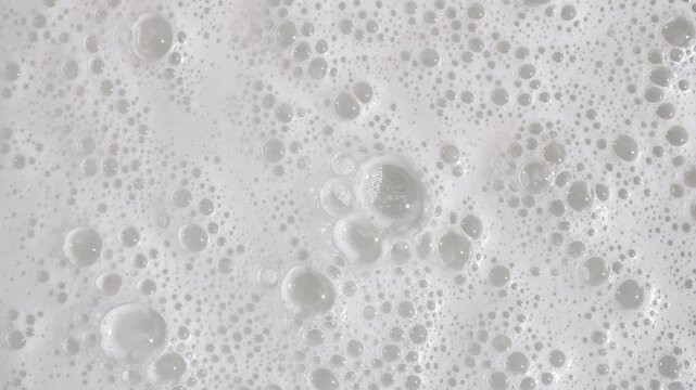 Texture of white soap foam with bubbles abstract background. Soap sud macro structure. Bathtup Soap Foam. Natural White Shampoo Bubbles Motion. High quality 4k footage