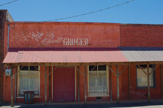 Historic Red Brick Storefronts on Small Town Main Street With Vintage Architecture on a Quiet Summer Afternoon Editorial Use Only Parrot, GA,  USA, May 14, 2026 vintage architectural details, a covere