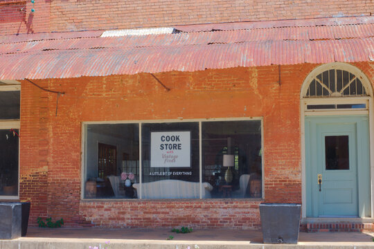 Historic Red Brick Storefronts on Small Town Main Street With Vintage Architecture on a Quiet Summer Afternoon Editorial Use Only Parrot, GA,  USA, May 14, 2026 vintage architectural details, a covere