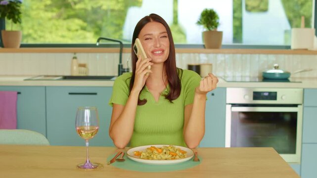 Happy young woman talking on smartphone during dinner, dynamic 4K slow motion