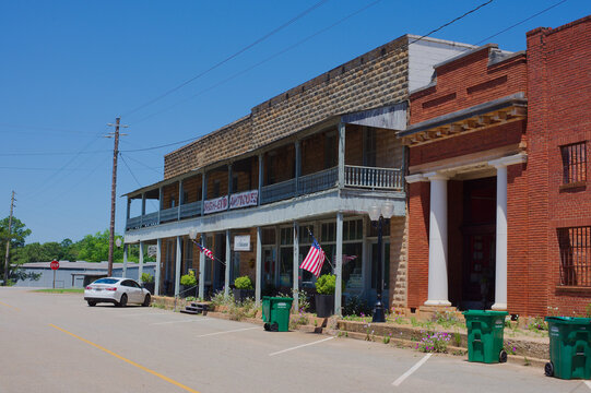 Historic Red Brick Storefronts on Small Town Main Street With Vintage Architecture on a Quiet Summer Afternoon Editorial Use Only Parrot, GA,  USA, May 14, 2026 vintage architectural details, a covere