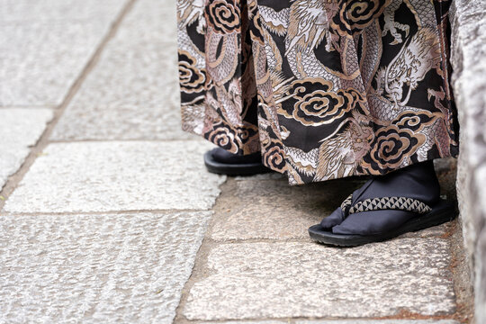 Man wearing traditional footwear with a kimono (Zori or Geta) (formal) or Geta features a V-shaped strap (hanao) and worn with split-toe socks Tabi