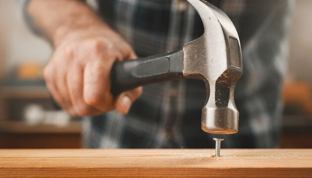 carpenter using a hammer to hit a nail