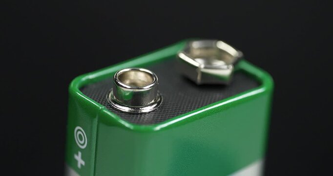 Nine-volt battery, or 9-volt battery - electric battery that supplies a nominal voltage of 9 volts. Green 9-volt battery ready to power devices