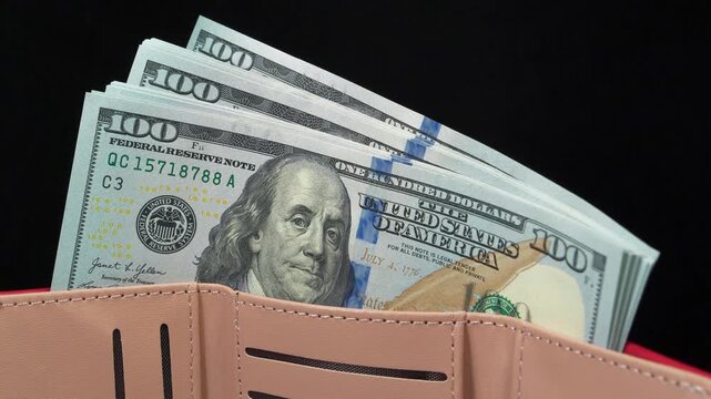 Cash. New 100 dollar bills, USD. Wallet filled with a stack of new hundred-dollar bills. New hundred dollar bills in a wallet