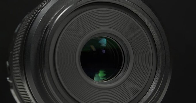 Black macro camera lens, zoom-in video on black backdrop