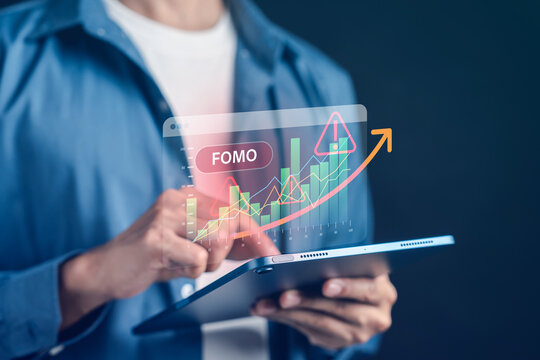 Fear of missing out FOMO investment risk warning and market bubble. Man touching digital display with red alert sign and upward chart on tablet.