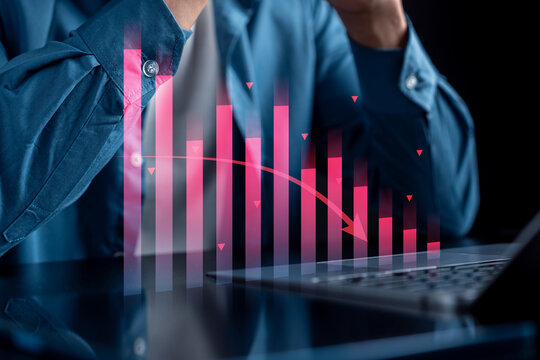 Heavy stock market crash and financial economic crisis recession. Stressed man working on laptop with red downward arrow chart for investment loss.