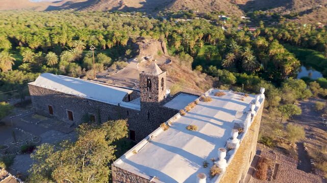 Explore the Mission Church of Santa Rosalia in Mulege Baja California Sur surrounded by palm trees and mountains near the Sea of Cortez.