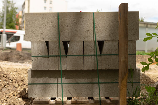 Pallet of precast blocks prepared. Prepared precast concrete segments securely placed on pallet beside leveling instruments for construction installation