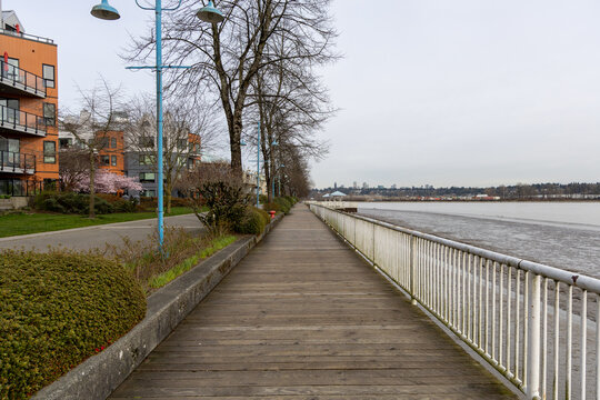 Empty Waterfront Boardwalk Along the Fraser River in New Westminster, Vancouver BC With Modern Apartments