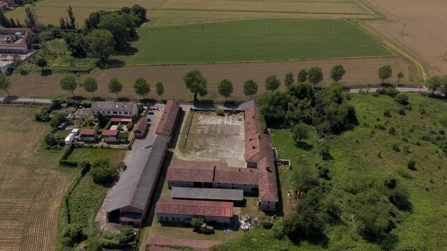 Rural Estate Aerial View: An aerial perspective captures a sprawling rural estate, featuring a large courtyard, agricultural fields, and surrounding greenery, showcasing a quiet countryside existence.